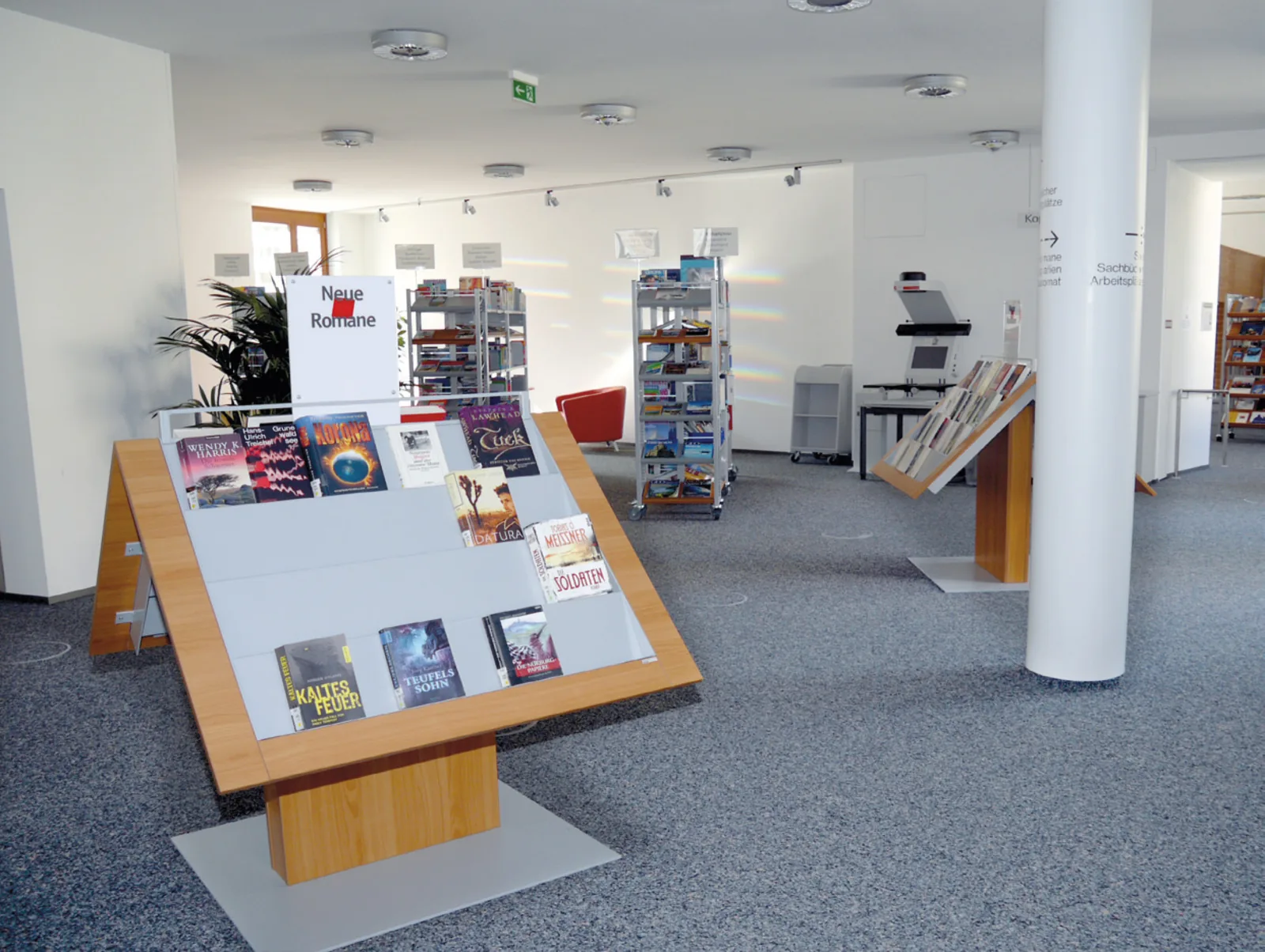 Verschiedene Medienpräsenter in lockerer Aufstellung bieten dabei einen hohen Informationscharakter — Stadtbibliothek München — Neuhauser Trafo, München